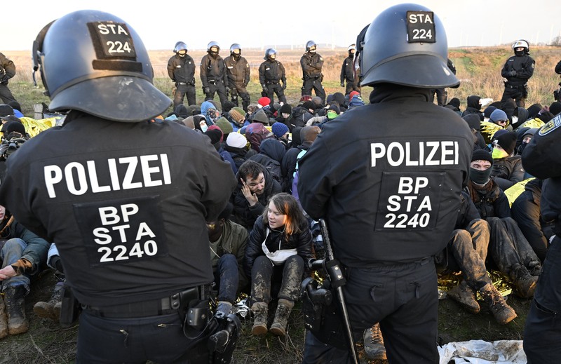 Police officers carry Swedish climate activist Greta Thunberg away from the edge of the Garzweiler II opencast lignite mine during a protest action by climate activists after the clearance of Luetzerath, Germany, Tuesday, Jan. 17, 2023. After the eviction of Luetzerath ended on Sunday, coal opponents continued their protests on Tuesday at several locations in North Rhine-Westphalia. (Federico Gambarini/dpa via AP)