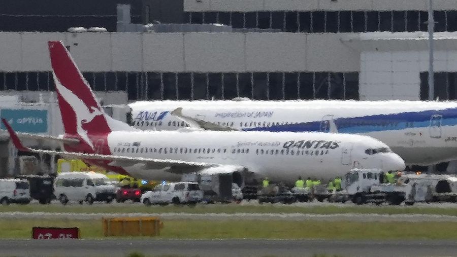 A Qantas Boeing 737-800 aircraft operating as flight QF144 is seen past heat haze after its safe landing at the Sydney International Airport on January 18, 2023. - Ambulance services scrambled at Sydney airport on January 18 to meet an incoming Qantas plane that issued a mid-air mayday alert with engine trouble before landing safely. (Photo by Andrew LEESON / AFP) (Photo by ANDREW LEESON/AFP via Getty Images)