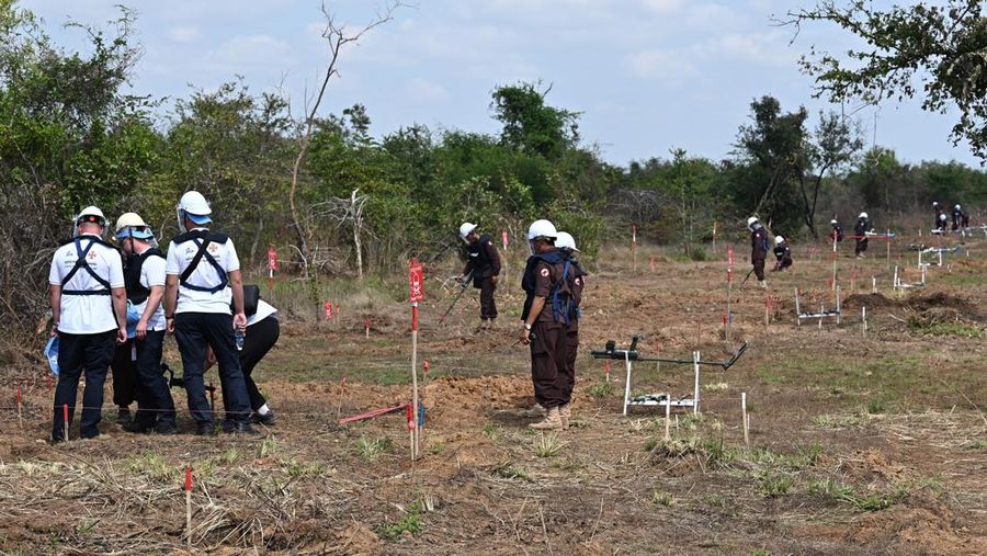 Para penjinak ranjau Ukraina menyaksikan ledakan bom yang terkendali di sebuah ladang ranjau di desa Preytotoeung, provinsi Battambang, Kamboja, Kamis, 19 Januari 2023. Lima belas penjinak ranjau Ukraina dilatih oleh para ahli di Kamboja yang merupakan salah satu yang terbaik di dunia karena berpengalaman membersihkan sisa-sisa makanan perang selama hampir tiga dekade. (AP Photo/Heng Sinith)
