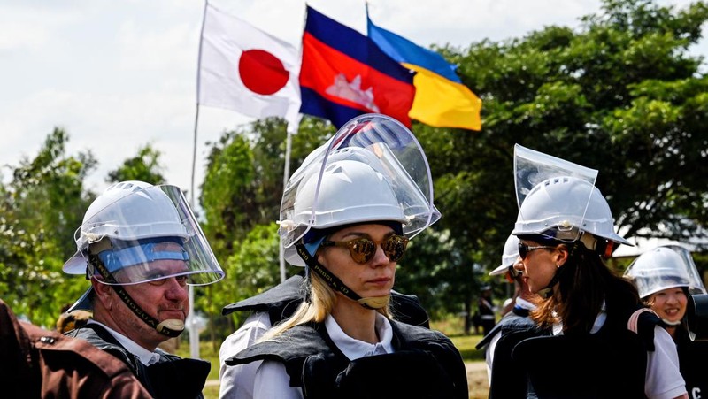 Para penjinak ranjau Ukraina menyaksikan ledakan bom yang terkendali di sebuah ladang ranjau di desa Preytotoeung, provinsi Battambang, Kamboja, Kamis, 19 Januari 2023. Lima belas penjinak ranjau Ukraina dilatih oleh para ahli di Kamboja yang merupakan salah satu yang terbaik di dunia karena berpengalaman membersihkan sisa-sisa makanan perang selama hampir tiga dekade. (AP Photo/Heng Sinith)