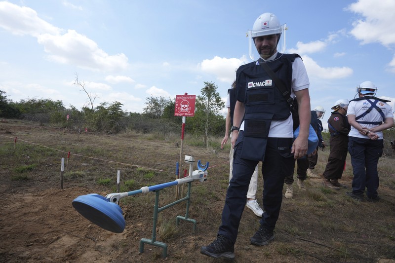 Para penjinak ranjau Ukraina menyaksikan ledakan bom yang terkendali di sebuah ladang ranjau di desa Preytotoeung, provinsi Battambang, Kamboja, Kamis, 19 Januari 2023. Lima belas penjinak ranjau Ukraina dilatih oleh para ahli di Kamboja yang merupakan salah satu yang terbaik di dunia karena berpengalaman membersihkan sisa-sisa makanan perang selama hampir tiga dekade. (AP Photo/Heng Sinith)