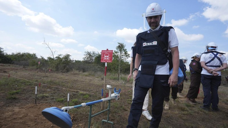 Para penjinak ranjau Ukraina menyaksikan ledakan bom yang terkendali di sebuah ladang ranjau di desa Preytotoeung, provinsi Battambang, Kamboja, Kamis, 19 Januari 2023. Lima belas penjinak ranjau Ukraina dilatih oleh para ahli di Kamboja yang merupakan salah satu yang terbaik di dunia karena berpengalaman membersihkan sisa-sisa makanan perang selama hampir tiga dekade. (AP Photo/Heng Sinith)