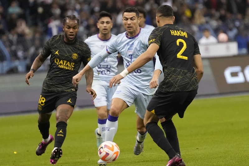 Cristiano Ronaldo meringis bermain untuk XI gabungan tim Arab Saudi Al Nassr dan Al Hilal diapit oleh pemain PSG Lionel Messi dan rekan setimnya Neymar dan Marquinhos selama pertandingan sepak bola persahabatan, di Stadion Universitas King Saud, di Riyadh, Arab Saudi, Kamis, 19 Januari 2023. (AP Photo/Hussein Malla)