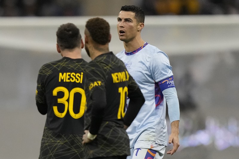 Cristiano Ronaldo meringis bermain untuk XI gabungan tim Arab Saudi Al Nassr dan Al Hilal diapit oleh pemain PSG Lionel Messi dan rekan setimnya Neymar dan Marquinhos selama pertandingan sepak bola persahabatan, di Stadion Universitas King Saud, di Riyadh, Arab Saudi, Kamis, 19 Januari 2023. Cristiano Ronaldo meringis bermain untuk XI gabungan tim Arab Saudi Al Nassr dan Al Hilal diapit oleh pemain PSG Lionel Messi dan rekan setimnya Neymar dan Marquinhos selama pertandingan sepak bola persahabatan, di Stadion Universitas King Saud, di Riyadh, Arab Saudi, Kamis, 19 Januari 2023. (AP Photo/Hussein Malla)
