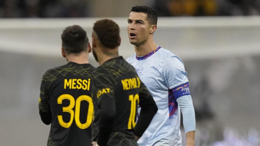 Cristiano Ronaldo meringis bermain untuk XI gabungan tim Arab Saudi Al Nassr dan Al Hilal diapit oleh pemain PSG Lionel Messi dan rekan setimnya Neymar dan Marquinhos selama pertandingan sepak bola persahabatan, di Stadion Universitas King Saud, di Riyadh, Arab Saudi, Kamis, 19 Januari 2023. (AP Photo/Hussein Malla)