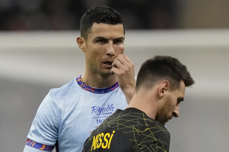 Cristiano Ronaldo meringis bermain untuk XI gabungan tim Arab Saudi Al Nassr dan Al Hilal diapit oleh pemain PSG Lionel Messi dan rekan setimnya Neymar dan Marquinhos selama pertandingan sepak bola persahabatan, di Stadion Universitas King Saud, di Riyadh, Arab Saudi, Kamis, 19 Januari 2023. Cristiano Ronaldo meringis bermain untuk XI gabungan tim Arab Saudi Al Nassr dan Al Hilal diapit oleh pemain PSG Lionel Messi dan rekan setimnya Neymar dan Marquinhos selama pertandingan sepak bola persahabatan, di Stadion Universitas King Saud, di Riyadh, Arab Saudi, Kamis, 19 Januari 2023. (AP Photo/Hussein Malla)
