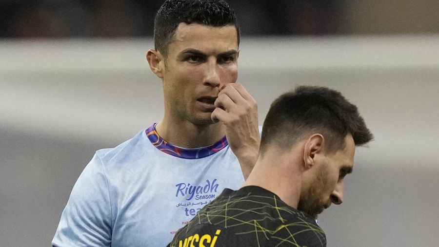 Cristiano Ronaldo memberi isyarat bermain untuk XI gabungan tim Arab Saudi Al Nassr dan Al Hilal diapit oleh pemain PSG Lionel Messi selama pertandingan sepak bola persahabatan, di Stadion Universitas King Saud, di Riyadh, Arab Saudi, Kamis, 19 Januari 2023. (AP Photo/Hussein Malla)