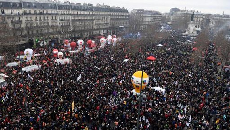 Para pengunjuk rasa berbaris melalui jalan-jalan Paris sebagai bagian dari protes dan pemogokan nasional terhadap rencana reformasi Pensiun Presiden Macron dan kenaikan biaya hidup pada 19 Januari 2023 di Paris, Prancis. Menyusul pengumuman pemerintah Prancis untuk mendorong usia pensiun dari 62 menjadi 64, serikat pekerja menyerukan aksi sosial massal dengan karyawan di bidang transportasi, pendidikan, energi, dan layanan kesehatan bergabung dengan pemogokan nasional, dengan protes besar di seluruh Prancis. Serikat CGT Prancis juga mengancam akan memutus pasokan listrik untuk anggota parlemen dan pengusaha di tengah pemogokan nasional. (Kiran Ridley/Getty Images)