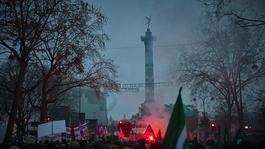 Para pengunjuk rasa berbaris melalui jalan-jalan Paris sebagai bagian dari protes dan pemogokan nasional terhadap rencana reformasi Pensiun Presiden Macron dan kenaikan biaya hidup pada 19 Januari 2023 di Paris, Prancis. Menyusul pengumuman pemerintah Prancis untuk mendorong usia pensiun dari 62 menjadi 64, serikat pekerja menyerukan aksi sosial massal dengan karyawan di bidang transportasi, pendidikan, energi, dan layanan kesehatan bergabung dengan pemogokan nasional, dengan protes besar di seluruh Prancis. Serikat CGT Prancis juga mengancam akan memutus pasokan listrik untuk anggota parlemen dan pengusaha di tengah pemogokan nasional. (Kiran Ridley/Getty Images)