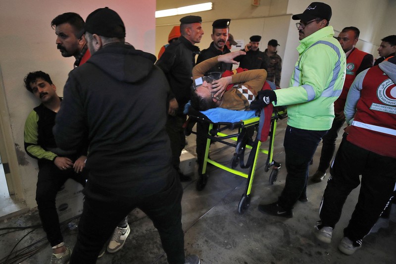 Anggota tim keamanan stadion Irak membawa seorang penggemar sepak bola yang terluka ke area darurat di Stadion Internasional Basra menyusul penyerbuan menjelang pertandingan final Piala Teluk Arab malam ini antara Irak dan Oman, pada 19 Januari 2023 di Basra. Anggota tim keamanan stadion Irak membawa seorang penggemar sepak bola yang terluka ke area darurat di Stadion Internasional Basra menyusul penyerbuan menjelang pertandingan final Piala Teluk Arab malam ini antara Irak dan Oman, pada 19 Januari 2023 di Basra. - Satu orang tewas dan puluhan lainnya terluka ketika terjadi penyerbuan di luar stadion sepak bola di Irak selatan beberapa jam sebelum final Piala Teluk, kata sumber medis dan keamanan. (HUSSEIN FALEH/AFP via Getty Images)
