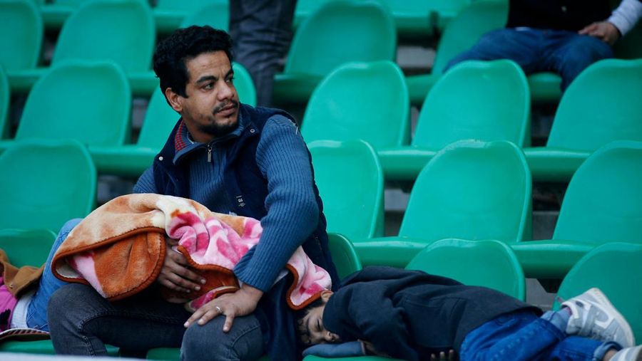 Anggota tim keamanan stadion Irak membawa seorang penggemar sepak bola yang terluka ke area darurat di Stadion Internasional Basra menyusul penyerbuan menjelang pertandingan final Piala Teluk Arab malam ini antara Irak dan Oman, pada 19 Januari 2023 di Basra. - Satu orang tewas dan puluhan lainnya terluka ketika terjadi penyerbuan di luar stadion sepak bola di Irak selatan beberapa jam sebelum final Piala Teluk, kata sumber medis dan keamanan. (HUSSEIN FALEH/AFP via Getty Images)