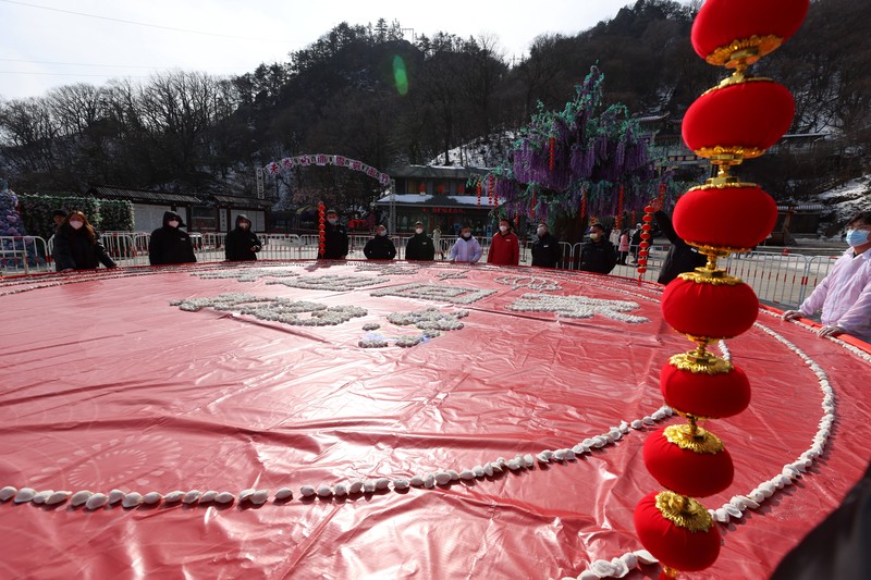 Pemandangan udara ribuan pangsit membentuk pola bertuliskan 'Selamat Datang di Rumah' di Area Pemandangan Gunung Laojun pada Malam Tahun Baru Imlek pada 21 Januari 2023 di Luoyang, Provinsi Henan, Tiongkok. Pemandangan udara ribuan pangsit membentuk pola bertuliskan 'Selamat Datang di Rumah' di Area Pemandangan Gunung Laojun pada Malam Tahun Baru Imlek pada 21 Januari 2023 di Luoyang, Provinsi Henan, Tiongkok. (VCG/VCG via Getty Images)