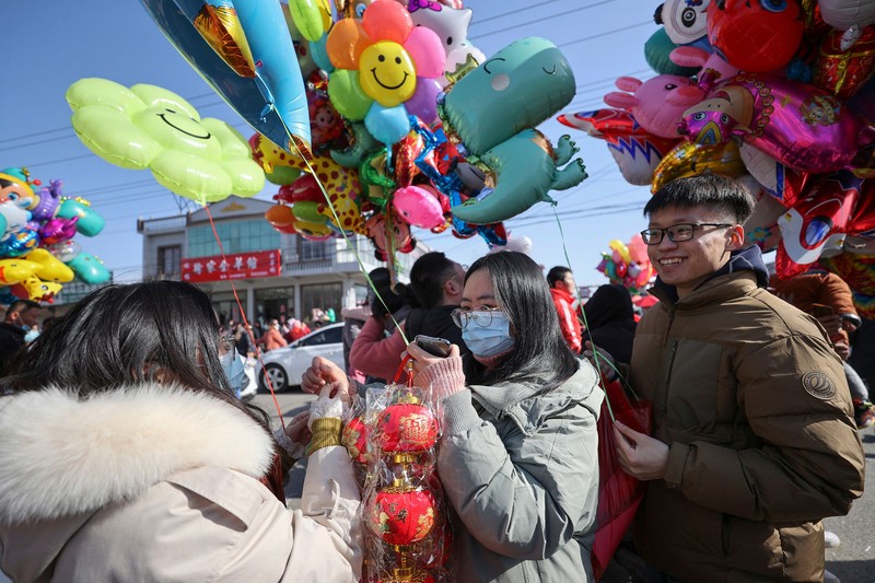 Orang-orang mengunjungi pasar bunga Festival Musim Semi tradisional yang dibuka kembali setelah ditutup karena penyebaran virus corona Covid-19 di Guangzhou, di provinsi Guangdong selatan China pada 20 Januari 2023, menjelang perayaan Tahun Baru Imlek Kelinci yang jatuh pada Januari 22. (STR/AFP via Getty Images)