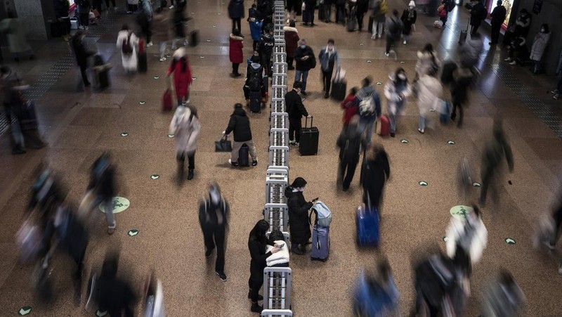 Penumpang menunggu kereta mereka tiba di stasiun kereta Beijing West menjelang tahun baru Imlek di Beijing pada 21 Januari 2023. (NOEL CELIS/AFP via Getty Images)