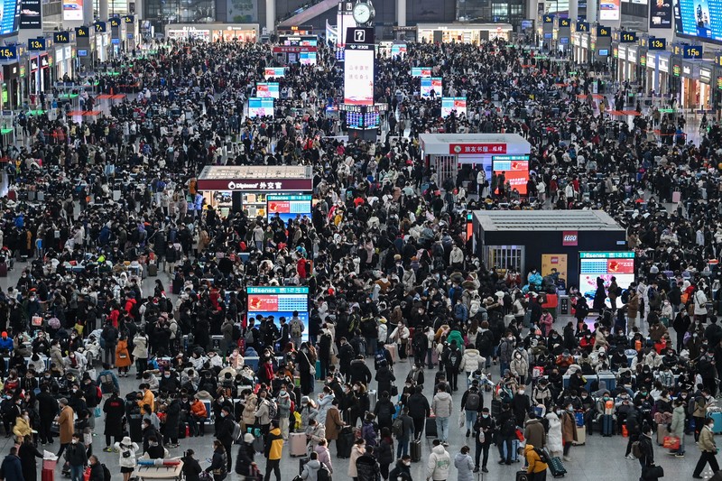 Penumpang menunggu kereta mereka tiba di stasiun kereta Beijing West menjelang tahun baru Imlek di Beijing pada 21 Januari 2023. (NOEL CELIS/AFP via Getty Images)