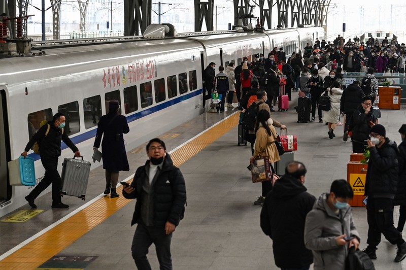 Penumpang menunggu kereta mereka tiba di stasiun kereta Beijing West menjelang tahun baru Imlek di Beijing pada 21 Januari 2023. (NOEL CELIS/AFP via Getty Images)