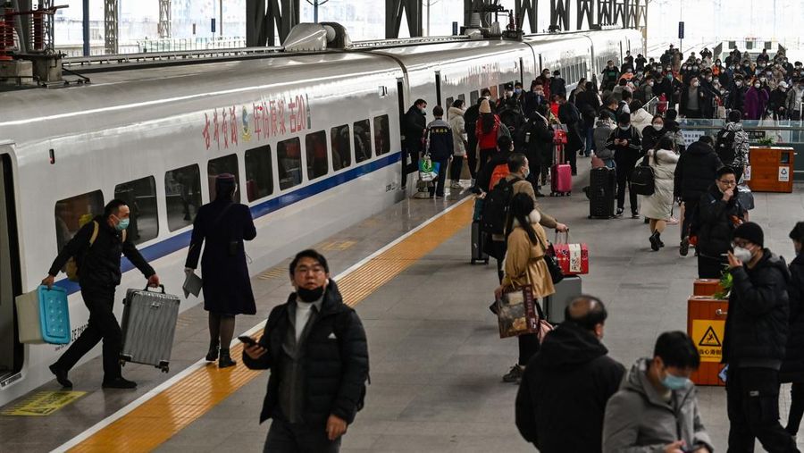 Penumpang menunggu kereta mereka tiba di stasiun kereta Beijing West menjelang tahun baru Imlek di Beijing pada 21 Januari 2023. (NOEL CELIS/AFP via Getty Images)