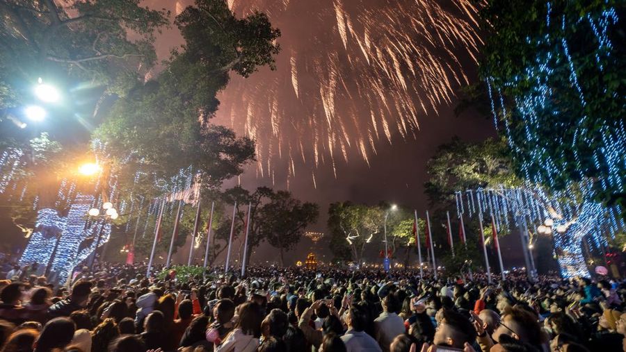 Orang-orang menonton pertunjukan kembang api untuk menandai perayaan Tahun Baru Imlek Tahun Kucing di Old Quarter pada 22 Januari 2023 di Hanoi, Vietnam. Tahun Baru Imlek juga dikenal sebagai Festival Musim Semi atau Tahun Baru Imlek, yang didasarkan pada kalender Cina Lunisolar, jatuh pada tanggal 22 Januari tahun ini dan menandai Tahun Kucing di Vietnam atau Tahun Kelinci di Cina, Korea, dan negara-negara Asia Timur dan Tenggara lainnya. (Linh Pham/Getty Images)