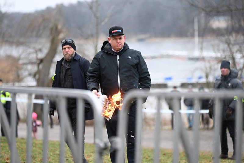 Pemimpin partai politik sayap kanan Denmark Stram Kurs Rasmus Paludan membakar salinan Alquran selama manifestasi di luar kedutaan Turki di Stockholm, Swedia, 21 Januari 2023. (Fredrik Sandberg/TT News Agency/via REUTERS)