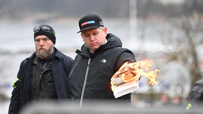 Pemimpin partai politik sayap kanan Denmark Stram Kurs Rasmus Paludan membakar salinan Alquran selama manifestasi di luar kedutaan Turki di Stockholm, Swedia, 21 Januari 2023. Pemimpin partai politik sayap kanan Denmark Stram Kurs Rasmus Paludan membakar salinan Alquran selama manifestasi di luar kedutaan Turki di Stockholm, Swedia, 21 Januari 2023. (Fredrik Sandberg/TT News Agency/via REUTERS)