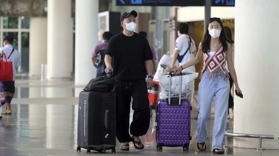 Chinese tourists carry their luggage on their arrival at the Ngurah Rai international airport in Bali, Indonesia on Sunday, Jan. 22, 2023. A direct flight from China landed in Indonesia’s resort island of Bali for the first time on Sunday in nearly three years after the route was suspended due to the pandemic. (AP Photo/Firdia Lisnawati)