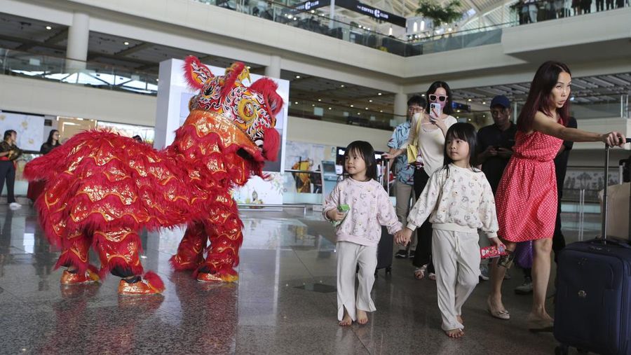 A lion dancer welcomes Chinese tourists on their arrival at Ngurah Rai international airport in Bali, Indonesia on Sunday, Jan. 22, 2023. A direct flight from China landed in Indonesia's resort island of Bali for the first time on Sunday in nearly three years after the route was cancelled due to the pandemic. (AP Photo/Firdia Lisnawati)