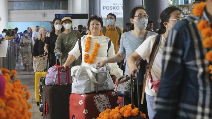 Chinese tourists arrive at Ngurah Rai international airport in Bali, Indonesia on Sunday, Jan. 22, 2023. A direct flight from China landed in Indonesia's resort island of Bali for the first time on Sunday in nearly three years after the route was cancelled due to the pandemic.  (AP Photo/Firdia Lisnawati)