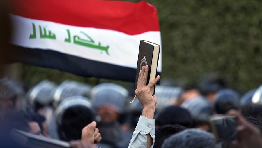Seorang pengunjuk rasa memegang Alquran saat demonstrasi di depan kedutaan Swedia di Baghdad sebagai tanggapan atas pembakaran Alquran di Swedia, Senin, 23 Januari 2023. (AP/Hadi Mizban)