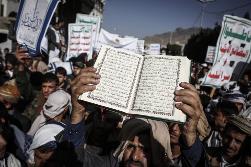 Warga Yaman mengangkat plakat dan salinan Alquran selama protes terhadap pembakaran salinan Alquran oleh seorang politisi Swedia. (dpa/picture alliance via Getty Images)