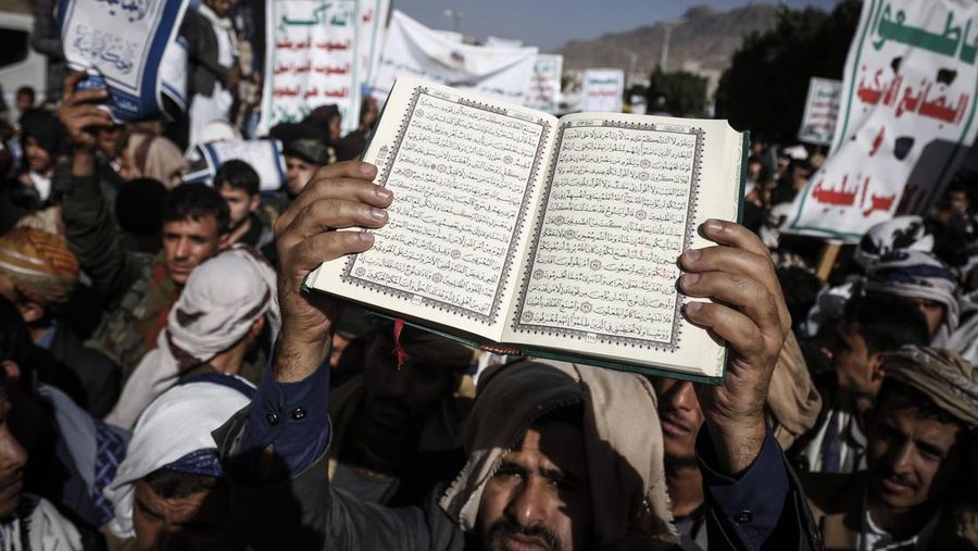 Warga Yaman mengangkat plakat dan salinan Alquran selama protes terhadap pembakaran salinan Alquran oleh seorang politisi Swedia. (dpa/picture alliance via Getty Images)