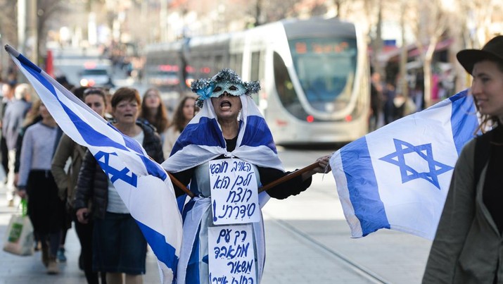 A woman holding Israeli national flags protests on Jerusalem's Jaffa Street.
On Thursday, February 6, 2020, in Jerusalem, Israel. (Photo by Artur Widak/NurPhoto via Getty Images)