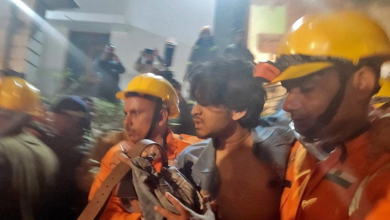Anggota penyelamat memindahkan puing-puing setelah blok apartemen perumahan runtuh di Lucknow, India, 24 Januari 2023. (REUTERS/Pawan Kumar)