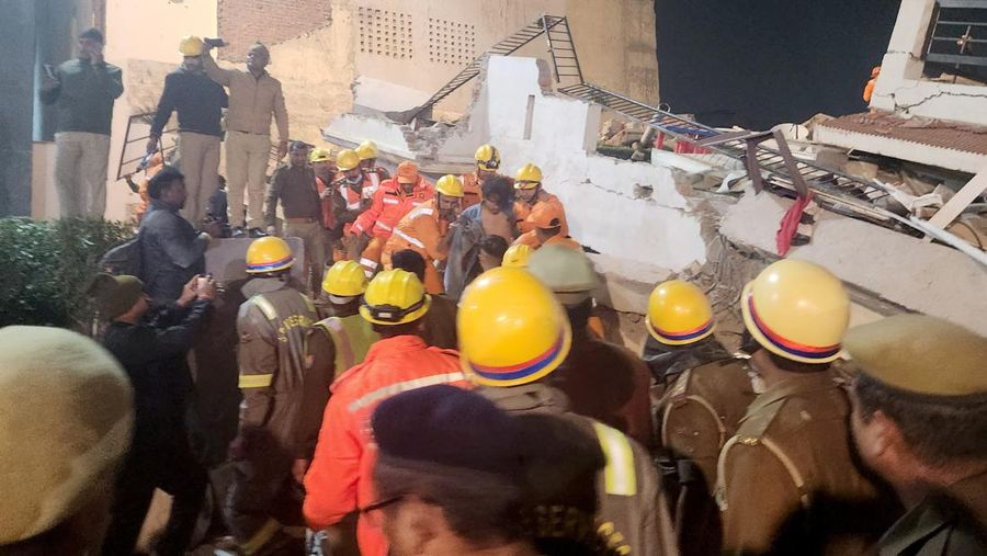 Anggota penyelamat memindahkan puing-puing setelah blok apartemen perumahan runtuh di Lucknow, India, 24 Januari 2023. (REUTERS/Pawan Kumar)