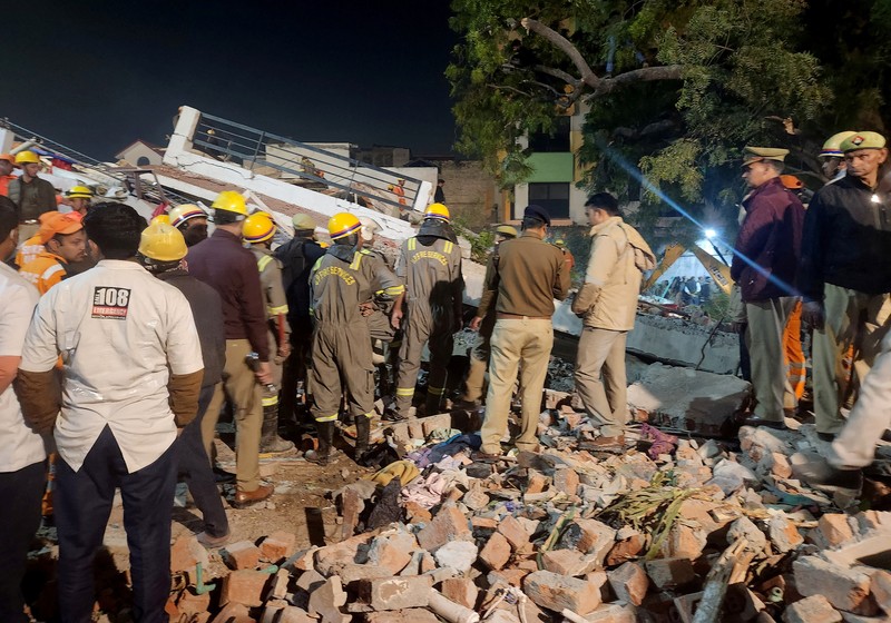 Anggota penyelamat memindahkan puing-puing setelah blok apartemen perumahan runtuh di Lucknow, India, 24 Januari 2023. (REUTERS/Pawan Kumar)