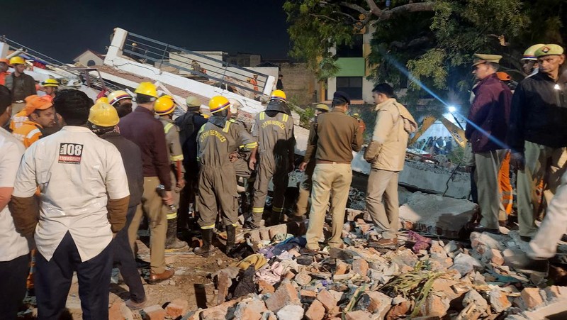 Anggota penyelamat memindahkan puing-puing setelah blok apartemen perumahan runtuh di Lucknow, India, 24 Januari 2023. (REUTERS/Pawan Kumar)