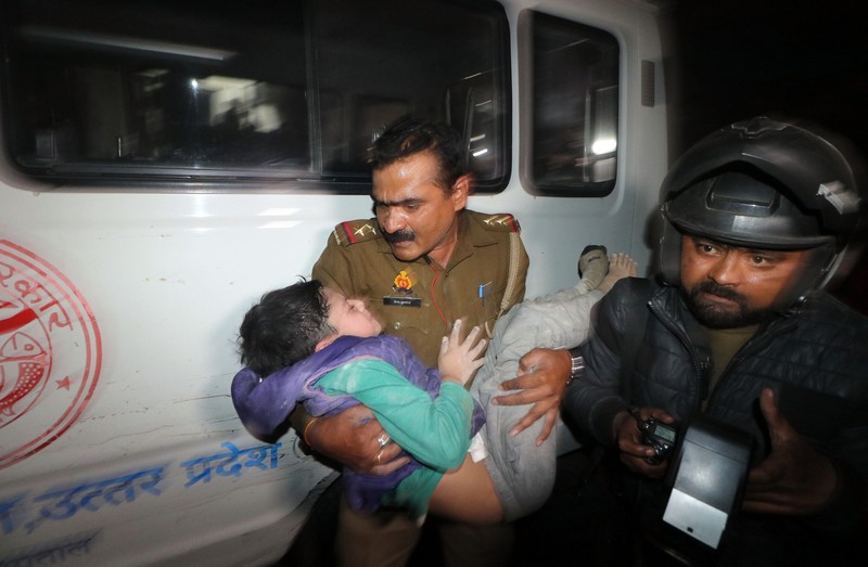 Anggota penyelamat memindahkan puing-puing setelah blok apartemen perumahan runtuh di Lucknow, India, 24 Januari 2023. (REUTERS/Pawan Kumar)