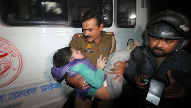 Anggota penyelamat memindahkan puing-puing setelah blok apartemen perumahan runtuh di Lucknow, India, 24 Januari 2023. (REUTERS/Pawan Kumar)