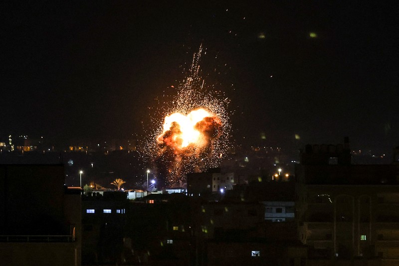 Api dan asap mengepul di atas gedung-gedung di Kota Gaza saat Israel melancarkan serangan udara ke kantong Palestina pada awal 27 Januari 2023. (AFP via Getty Images/MAHMUD HAMS)