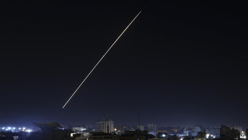 Api dan asap mengepul di atas gedung-gedung di Kota Gaza saat Israel melancarkan serangan udara ke kantong Palestina pada awal 27 Januari 2023. (AFP via Getty Images/MAHMUD HAMS)