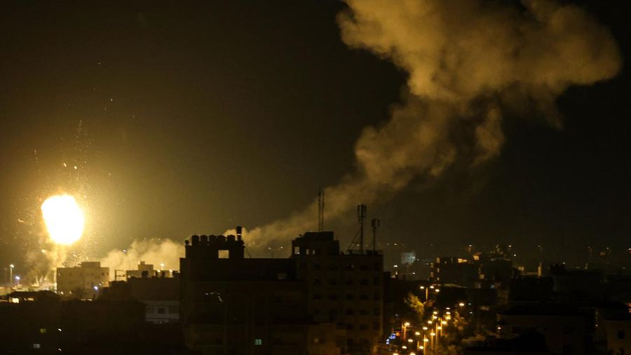 Api dan asap mengepul di atas gedung-gedung di Kota Gaza saat Israel melancarkan serangan udara ke kantong Palestina pada awal 27 Januari 2023. (AFP via Getty Images/MAHMUD HAMS)