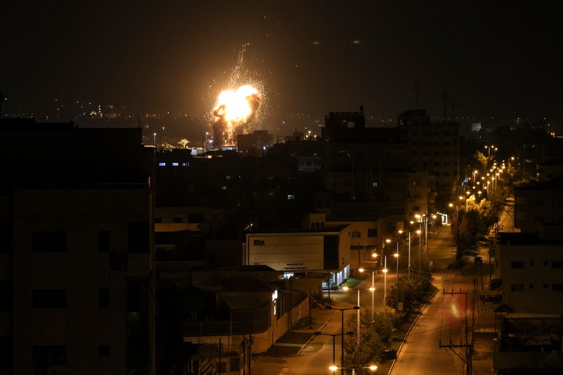 Api dan asap mengepul di atas gedung-gedung di Kota Gaza saat Israel melancarkan serangan udara ke kantong Palestina pada awal 27 Januari 2023. (AFP via Getty Images/MAHMUD HAMS) Api dan asap mengepul di atas gedung-gedung di Kota Gaza saat Israel melancarkan serangan udara ke kantong Palestina pada awal 27 Januari 2023. (AFP via Getty Images/MAHMUD HAMS)
