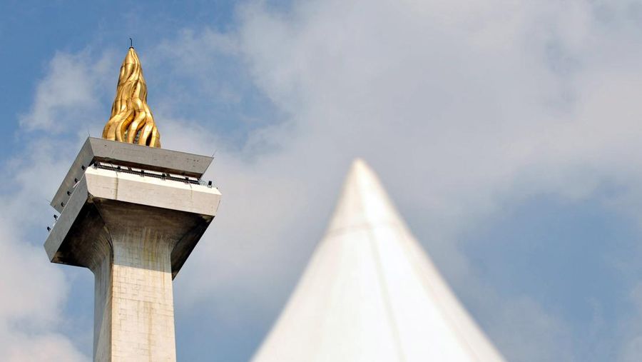 Sebuah gambar memperlihatkan Monumen Nasional atau Monas (kiri) dengan api berlapis emas melambangkan perjuangan kemerdekaan Indonesia berdiri setinggi 422 kaki di Jakarta pada tanggal 26/2/2010. AFP PHOTO / ADEK BERRY via Getty Images/File
