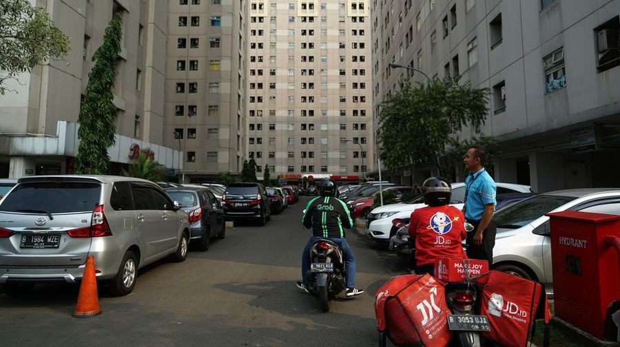 A Grab and a JD.id motorcycle drivers sit parked outside residential buildings in the Kalibata area of Jakarta, Indonesia, on Saturday, Aug. 11, 2018. Photographer: Dimas Ardian/Bloomberg via Getty Images As Wednesday's policy decision approaches, Bank Indonesia finds itself under pressure to raise the benchmark rate again even after increasing it by a combined 100 basis points since mid-May to stem a slide in the currency. Photographer: Dimas Ardian/Bloomberg via Getty Images