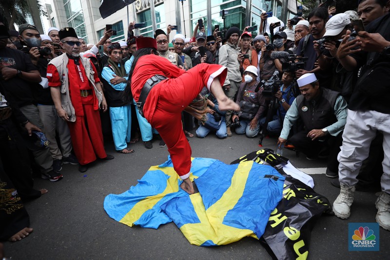 Sejumlah kelompok masyarakat yang tergabung dalam Aksi Bela Al-Quran melakukan aksi merobek dan membakar bendera Swedia di depan Kantor Kedutaan Besar (Kedubes) Swedia, Jakarta, Senin (30/1/2023). Peserta aksi mengecam tindakan Rasmus lantaran dianggap menista agama Islam dengan membakar Al-Qur'an.