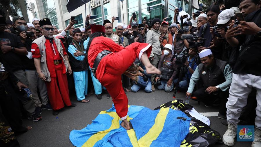 Sejumlah kelompok masyarakat yang tergabung dalam Aksi Bela Al-Quran melakukan aksi merobek dan membakar bendera Swedia di depan Kantor Kedutaan Besar (Kedubes) Swedia, Jakarta, Senin (30/1/2023). Peserta aksi mengecam tindakan Rasmus lantaran dianggap menista agama Islam dengan membakar Al-Qur'an.