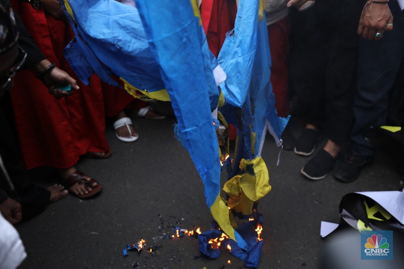 Sejumlah kelompok masyarakat yang tergabung dalam Aksi Bela Al-Quran melakukan aksi merobek dan membakar bendera Swedia di depan Kantor Kedutaan Besar (Kedubes) Swedia, Jakarta, Senin (30/1/2023). Peserta aksi mengecam tindakan Rasmus lantaran dianggap menista agama Islam dengan membakar Al-Qur'an.