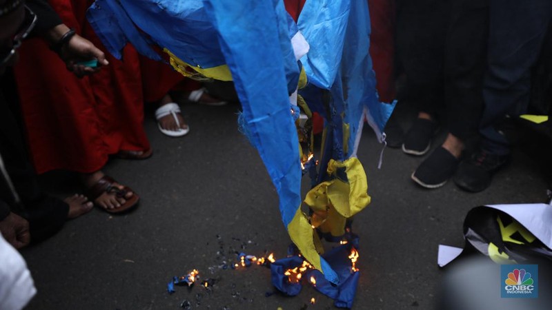 Sejumlah kelompok masyarakat yang tergabung dalam Aksi Bela Al-Quran melakukan aksi merobek dan membakar bendera Swedia di depan Kantor Kedutaan Besar (Kedubes) Swedia, Jakarta, Senin (30/1/2023). Peserta aksi mengecam tindakan Rasmus lantaran dianggap menista agama Islam dengan membakar Al-Qur'an.