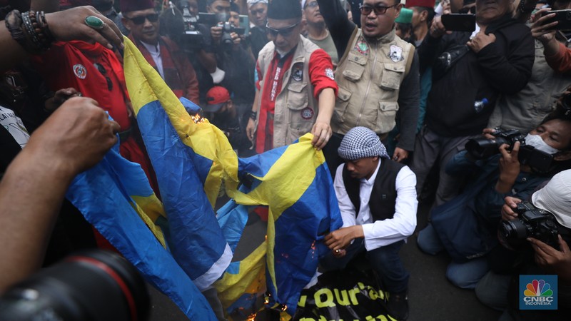 Warga Yaman mengangkat plakat dan salinan Alquran selama protes terhadap pembakaran salinan Alquran oleh seorang politisi Swedia. (dpa/picture alliance via Getty Images) Warga Yaman mengangkat plakat dan salinan Alquran selama protes terhadap pembakaran salinan Alquran oleh seorang politisi Swedia. (dpa/picture alliance via Getty Images)