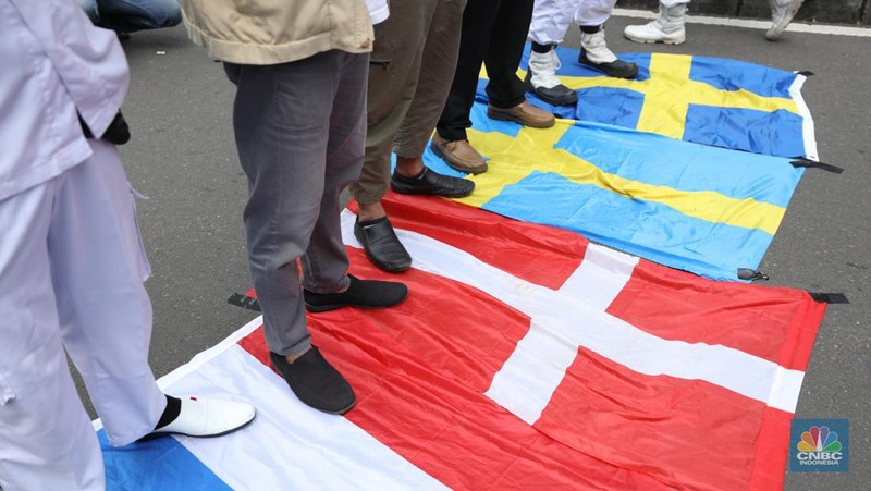 Sejumlah kelompok masyarakat yang tergabung dalam Aksi Bela Al-Quran menggelar aksi injak bendera Denmark, Swedia, dan Belanda di depan Kantor Kedutaan Besar (Kedubes) Swedia, Jakarta, Senin (30/1/2023). Peserta aksi mengecam tindakan Rasmus lantaran dianggap menista agama Islam dengan membakar Al-Qur'an. (CNBC Indonesia/Tri Susilo)