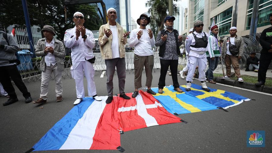 Sejumlah kelompok masyarakat yang tergabung dalam Aksi Bela Al-Quran menggelar aksi injak bendera Denmark, Swedia, dan Belanda di depan Kantor Kedutaan Besar (Kedubes) Swedia, Jakarta, Senin (30/1/2023). Peserta aksi mengecam tindakan Rasmus lantaran dianggap menista agama Islam dengan membakar Al-Qur'an. (CNBC Indonesia/Tri Susilo)